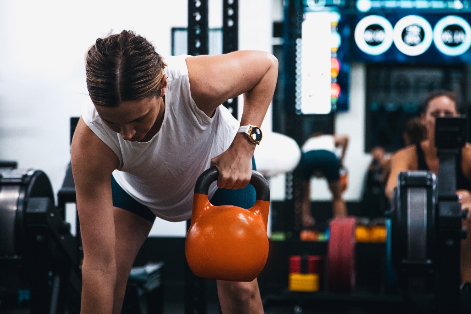 Body Fit Training female attendee lifting weight during session