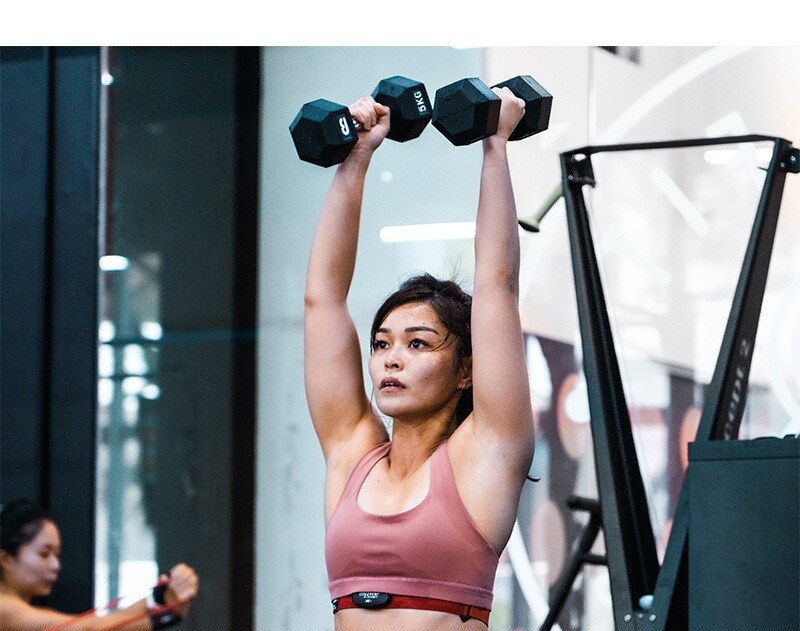 Body Fit Training studio female attendee demonstrating a workout with dumbbells