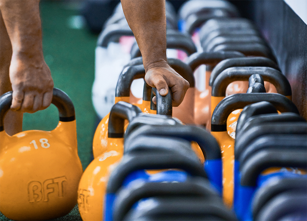 Body Fit Training session attendee grabbing BFT dumbbells