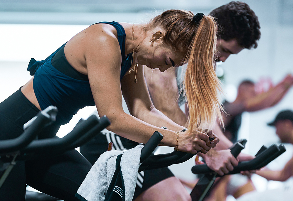 Body Fit Training studio attendees demonstrating a cycling workout