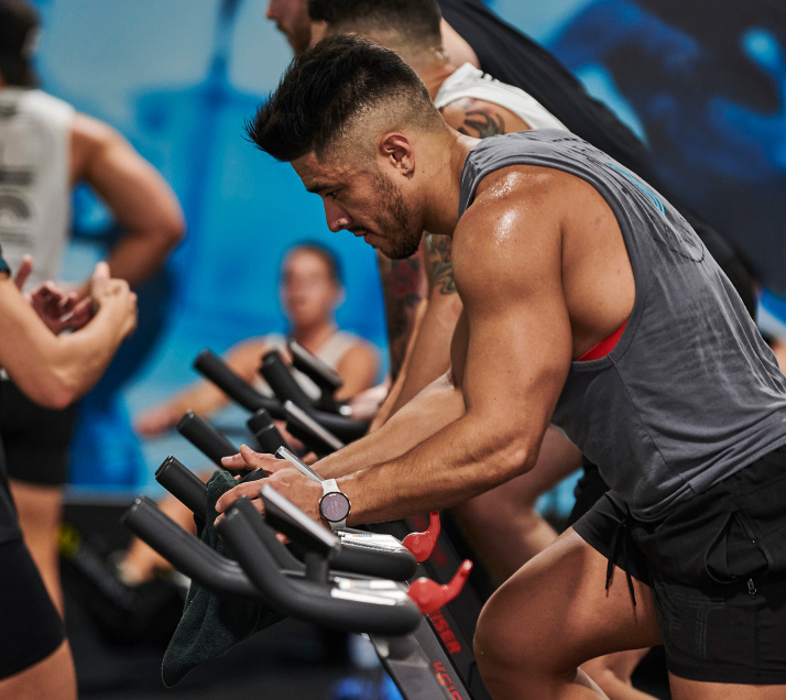 Man using an indoor cycling machine during a BFT class